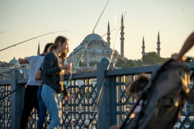 İstanbul, Türkiye 'deki Galata köprüsünde oltaları olan balıkçılar