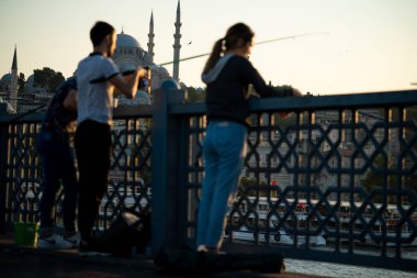 İstanbul, Türkiye 'deki Galata köprüsünde oltaları olan balıkçılar
