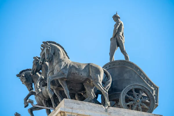 Güneşli bir günde Madrid 'deki Gran Va' nın çatısında dört atlı at arabası heykelleri.