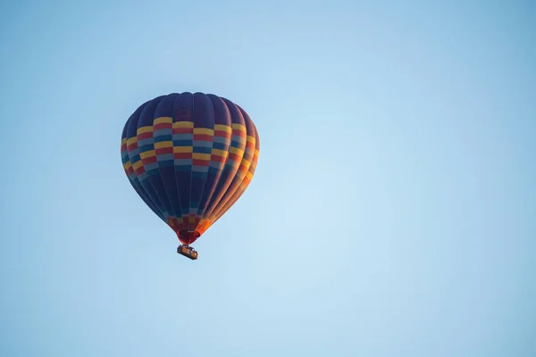 晴れた日の日没の間に旅客輸送のためのバスケットと澄んだ青い空を飛んでカラフルな気球は スペースをコピー — ストック写真