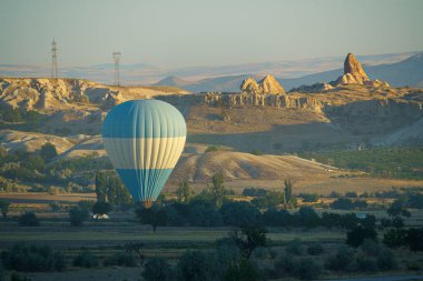 Güneşli bir yaz gününde Kapadokya üzerinde uçan balon sönüyor.