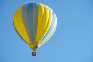 Türkiye 'nin başkenti Kapadokya' da güneşli bir günde açık mavi gökyüzü üzerinde uçan renkli balon, boşluğu kopyala