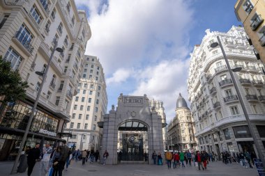 Madrid 'deki Gran Va metro istasyonunun tarihi gölgesi, Telefnica binası ve Gran Va caddesinin mavi gökyüzü ile güneşli bir günde manzarası