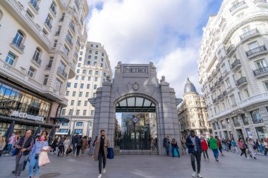 Madrid 'deki Gran Va metro istasyonunun tarihi gölgesi, Telefnica binası ve Gran Va caddesinin mavi gökyüzü ile güneşli bir günde manzarası