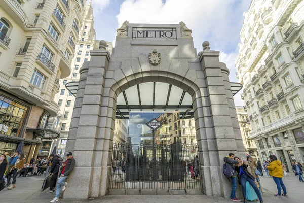 Madrid 'deki Gran Va metro istasyonunun tarihi gölgesi, Telefnica binası ve Gran Va caddesinin mavi gökyüzü ile güneşli bir günde manzarası