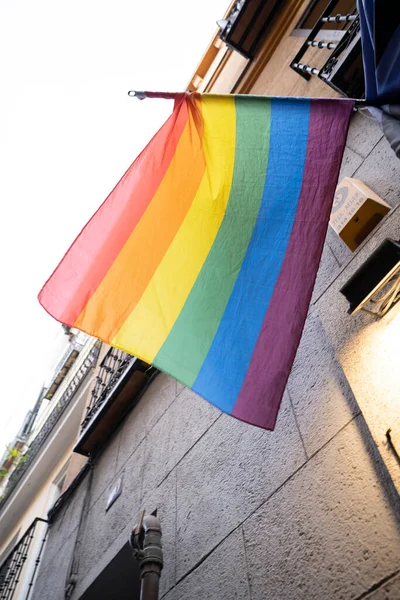 LGTBI haklarının savunulması lehine renkli bayraklar ve Madrid şehrindeki bir apartman bloğunun ön cephesinde ikili olmayan insanlar.