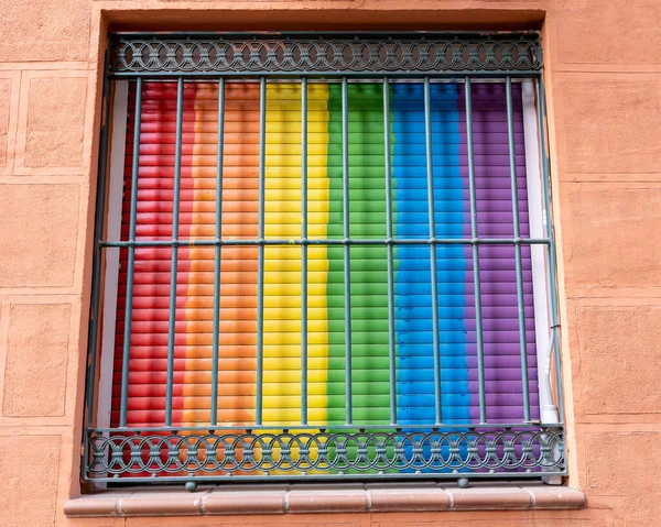 Blinds of a house with the colors of the flag of gay pride and LGTBI rights