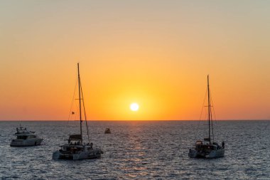 Santorini 'de, Yunan adalarında, yuvarlak ve turuncu güneşli bir gün batımı