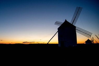 Toledo eyaletindeki Consuegra yel değirmenleri açık bir yaz günüyle gün batımında