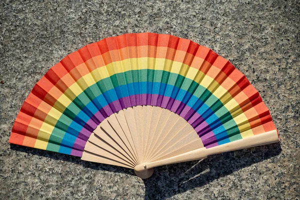 Fan with the multicolored gay flag, on the occasion of gay and LGBTI pride during a sunny summer day