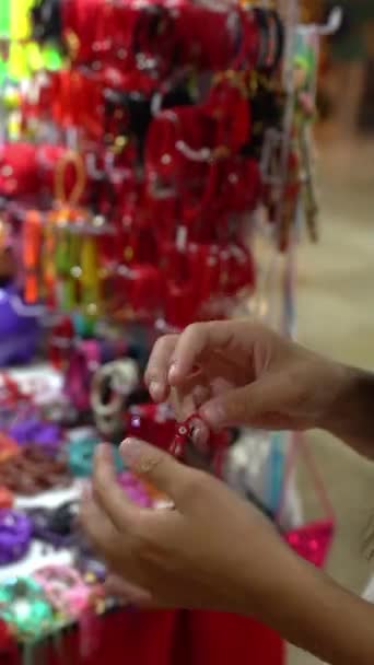Молодая латиноамериканка ищет подарочный браслет на Рождество на ярмарке — стоковое видео