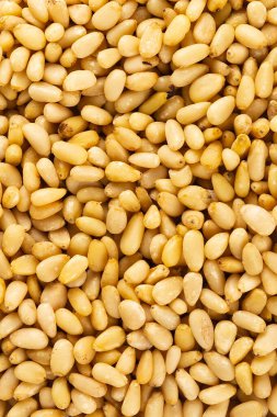 Peeled golden pine nuts top view background