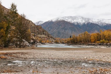 Mountain river surrounded by high rocks in Altai in autumn