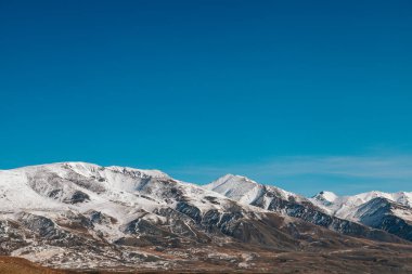 High cliffs in the mountains with snow on the peaks in Altai in autumn