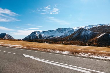 A road in the mountains with beautiful landscapes and views of rocks and peaks in Altai in autumn