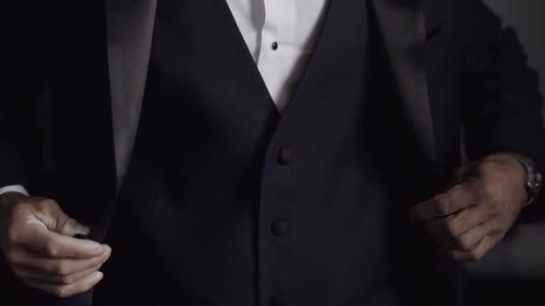 Närbild. Bröllop. Mannen fäster en knapp på en klassisk blå jacka — Stockvideo