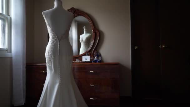 Abiti Couture visualizzati su manichini in negozio di abbigliamento da sposa una sposa cercando sul suo vestito, riflesso in elegante specchio ornato — Video Stock