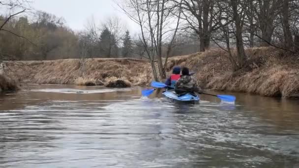 Indietro di uomo e donna voga in giubbotti di salvataggio nuotare in canoa sul fiume — Video Stock