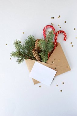 İçinde boş kağıt kart olan Noel mektubu, altın kurdeleli beyaz hediye kutusu, koyu mavi arka planda süslenmiş köknar dalları. Düz yerde, üst tarafta. Noel Baba 'ya Mektup.