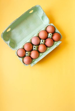 Arka planda karton tepside organik yumurtalar. Düz yatış, üst görünüm