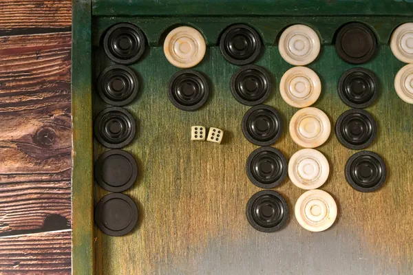 Tavla tahtasında siyah beyaz çipli bir zar..