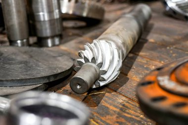 Kirişlerin üzerinde CNC makinesinde işlem yaptıktan sonra uzun sarmal bir teçhizat yatıyor..