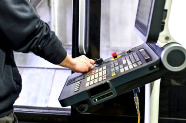 Adam CNC makinesinin uzaktan kumandasını kullanıyor..