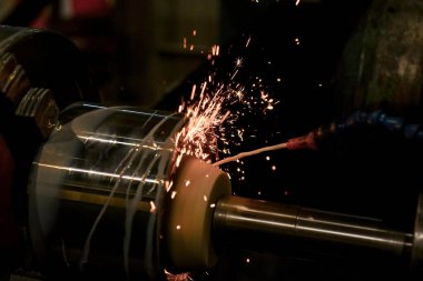 Makinenin iç kısmının öğütülmesi sırasında, soğutucu kıvılcımlar dökülür..