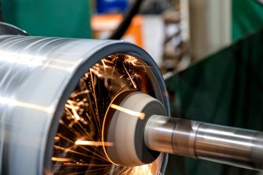 Makinedeki bir dairenin iç silindirik kısmını öğütürken kıvılcımlar yayılır.