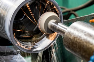 Makine, kıvılcımlar ve soğutucu üzerindeki çalışma parçasının içeriden öğütülmesi.