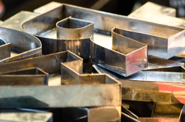 Bir el işi endüstrisinde paslanmaz çelikten yapılmış kabartmalı harfler koleksiyonu.