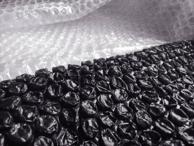 Siyah ve beyaz plastik ambalaj yüzeyi. Yüzeyinde cam veya elektronik veya hassas eşyalar paketlemek için kullanılan hava topları olan plastik tabaka