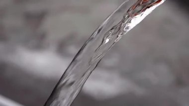 Sıçrama detayları ya da bulanık bir arkaplan üzerinde düşen suyun hareketi. yüksek hız berrak su jeti