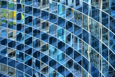 Geometrik desenli, modern bir ofis binasının eğri camlı cephesi