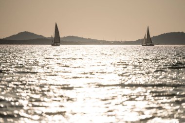 Günbatımında denizde yelkenli.