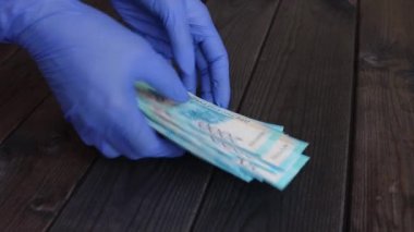 Eldivenli kadın eller masadan bir paket Rus rublesi alıp düzgünce yerine koyun..