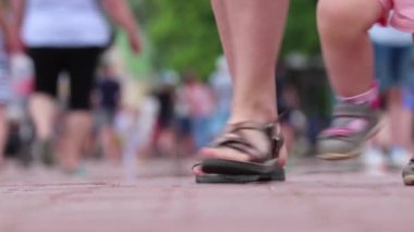 Odaklanamayan video. Sahildeki sette yürüyen insanların bacakları. Turistler ve tatilciler.