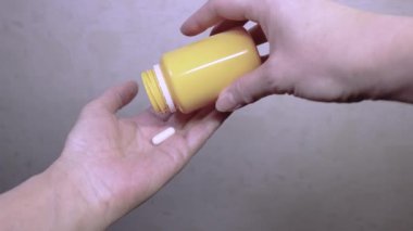Kadın paketten ilaç kapsüllerini avucunun içine boşaltıyor. Diyet hapları, sağlık ve sağlık hizmetleri.