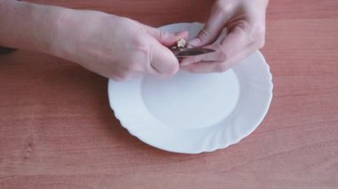 Tanınmayan bir kadın sarımsağı bıçakla soyar. Yemek pişirmek..