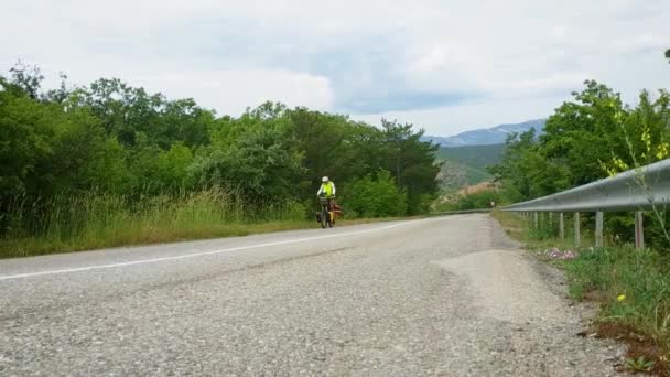 Kobieta Rowerzysta Jeździ Załadowanym Rowerem Asfaltowej Drodze Tle Górskiego Krajobrazu — Wideo stockowe