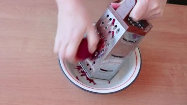 Bir kadın çorba için pancar rendeliyor. Sağlıklı beslenme ve çiğ gıda diyeti kavramı.