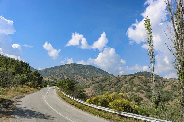 山や田舎の間の道路 積雲と青空 — ストック写真