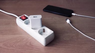 El, USB kablosunu akıllı telefonu şarj etmek için USB portuna takıyor. Seçici odak.