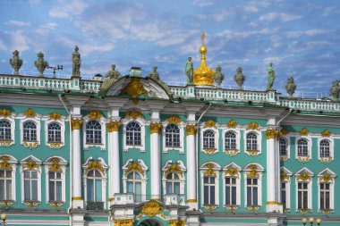 St. Petersburg 'daki Antik Kış Sarayı' nın (Rusya) dış cephesinin ayrıntıları. Yakın plan. Sayısız heykel, bitki desenli vazolar, duvarlar ve pencereler için mimari süslemeler. Bulutlu mavi gökyüzü 