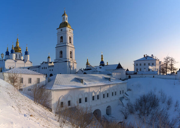 Вид на древний сибирский город Тобольск (Россия) на холмы в зимний солнечный день. Вид на город с множеством старинных церквей, золотыми куполами, высокими колокольнями на фоне ясного голубого неба 