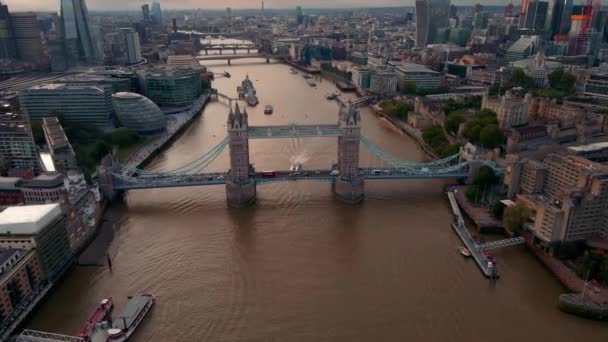タワーブリッジとロンドンシティビジネスセンターへの空中ビュー 日没直前 橋を渡る交通事故 — ストック動画