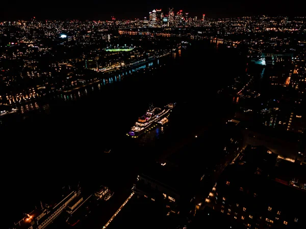 Splendida vista panoramica sul Tamigi fino al quartiere finanziario Canary Wharf di Londra durante la notte. Vista aerea drone — Foto Stock
