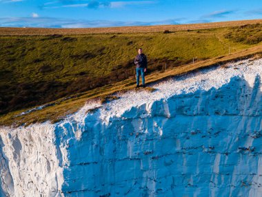 Adam Dover 'ın Beyaz Kayalıkları' nın kenarında duruyor. Seven Sisters Ulusal Parkı, Doğu Sussex, İngiltere Güney Sahili.