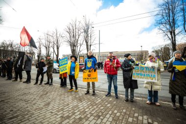 Riga, Letonya 26.02.2022: Ukrayna 'nın yanında dur. Savaşı ve Rus silahlı saldırgan Vladimir Putin 'in politikasını protesto etmek. Ukrayna 'yı savunan Letonyalılar. Küresel askeri çatışma, işgal