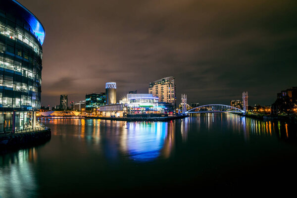 Манчестер, Великобритания. 15 сентября 2021: Ночной вид на бизнес-центр Манчестера. Корабельный канал в Солфорд-Квайсе и Траффорд - ночной выстрел в длинную экспозицию